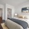 A spacious bedroom with hardwood floors and large windows