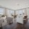 Luxury Apartments for Rent in Reston, VA - The Arbor at Halley Rise - Open Living Room with Stylized Wood-Inspired Flooring, Area Rug, Sofa, Coffee Table, Wingback Chairs, Floor-to-Ceiling Windows, and View of Kitchen and Dining Area.