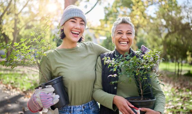 a couple of women holding plants